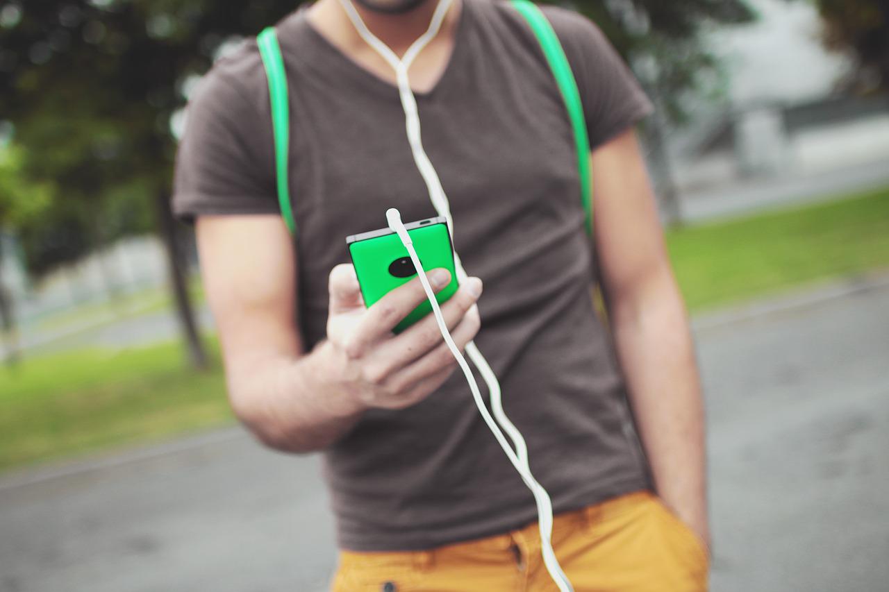 guy using smartphone and earphones